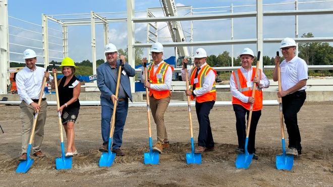staff standing with shovels on industrial site