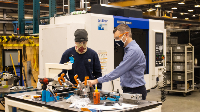 Two men working with machinery 