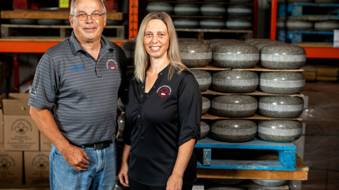 two people in front of curling stones