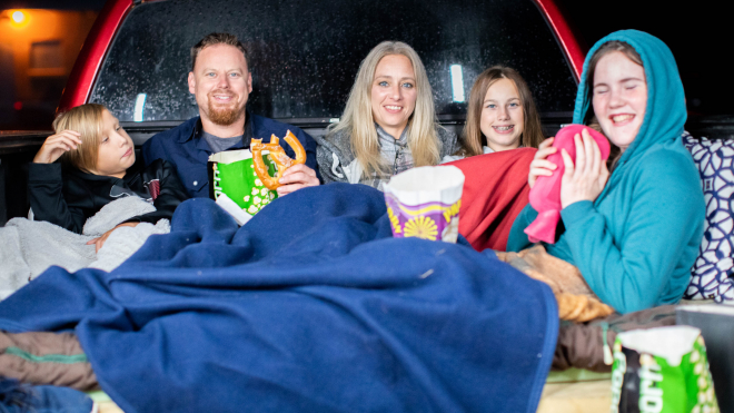 Family watching a movie at the drive in theatre