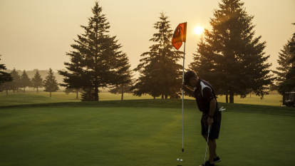 Man golfing with the sunset 