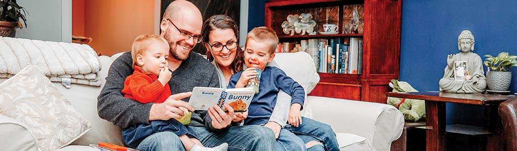 Family reading a story book together 