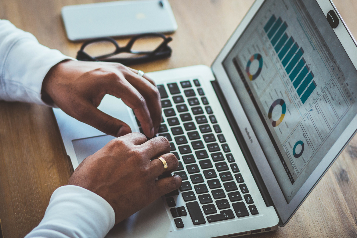 Hands on a laptop with graphs